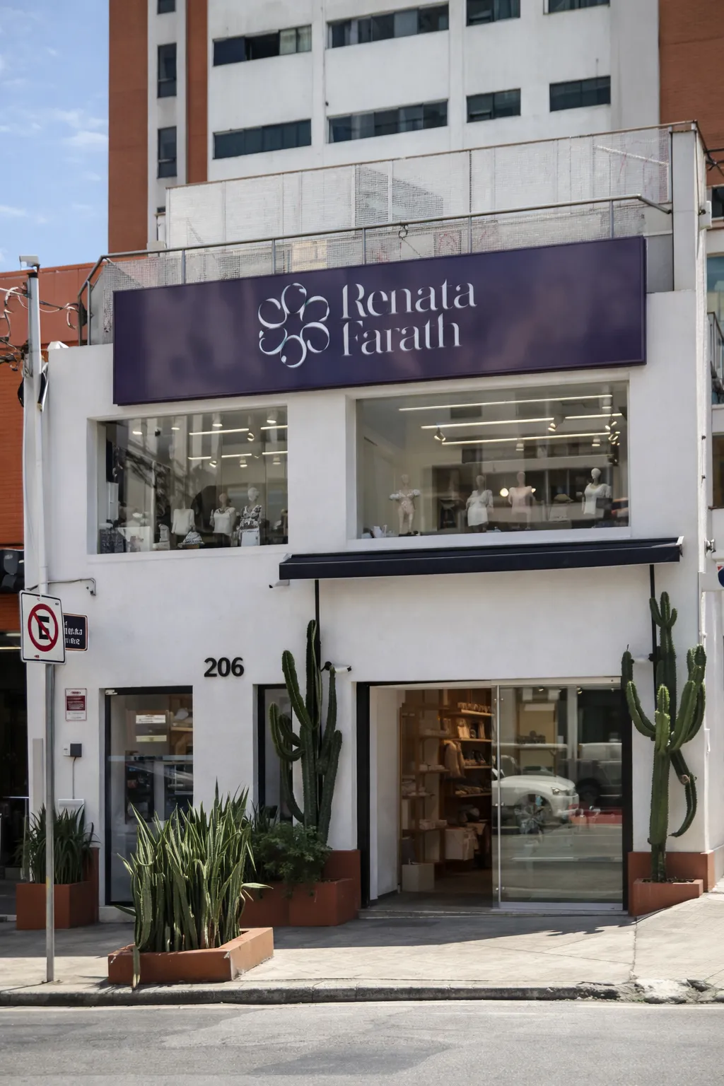 Fachada branca da Renata Farath Store com letreiro roxo, vitrines no andar de cima e cactos na calçada, R. Piracuama 206